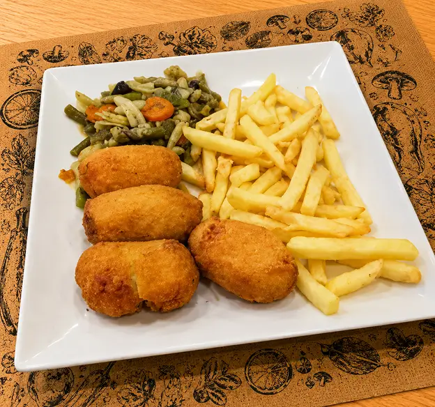 Croquetas con patatas fritas y verduras