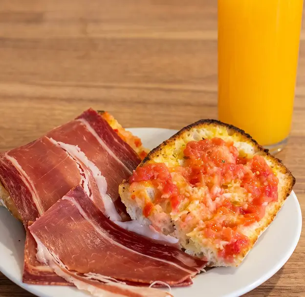 Tostada de tomate rallado con jamón y zumo de naranja